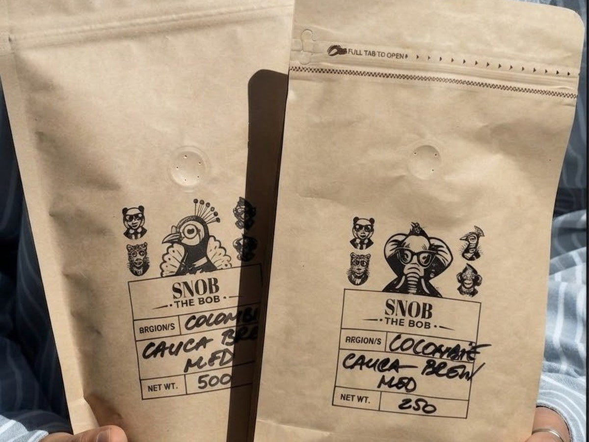 Deux sachets kraft Snob The Bob de café Cauca Colombie tenus en main